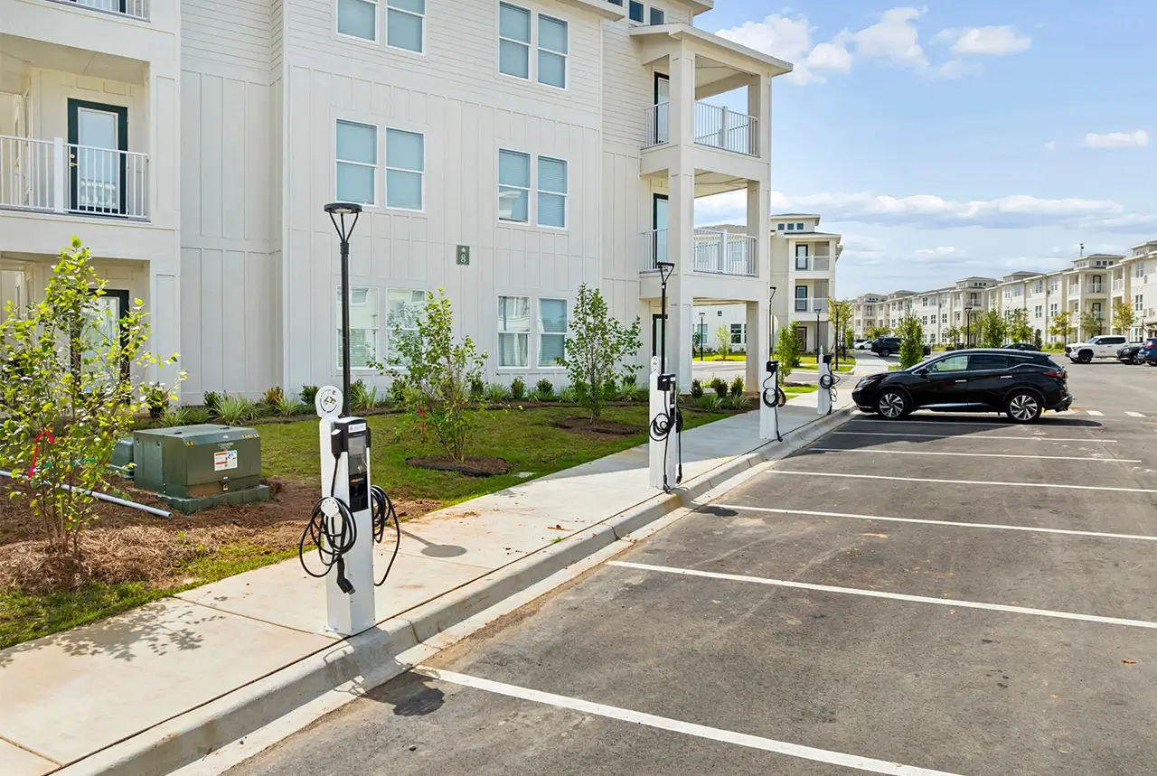 Parking lot with electric vehicle charging stations beside the apartment buildings